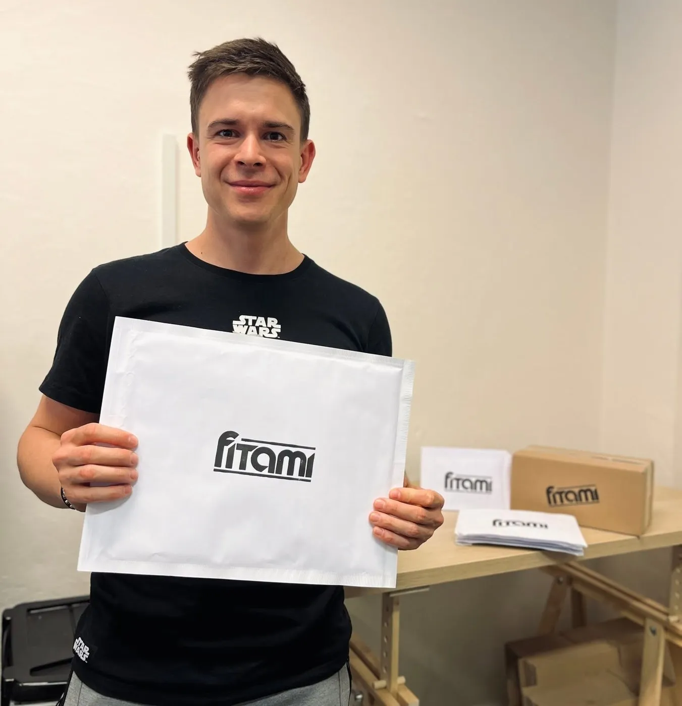 Filip drží bublinkovou obálku s vytištěným logem FITAMI